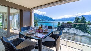 A balcony with a table set for breakfast, overlooking a lake and mountains. - Montreux Panoramic Views 4BD Apartment (Montreux)