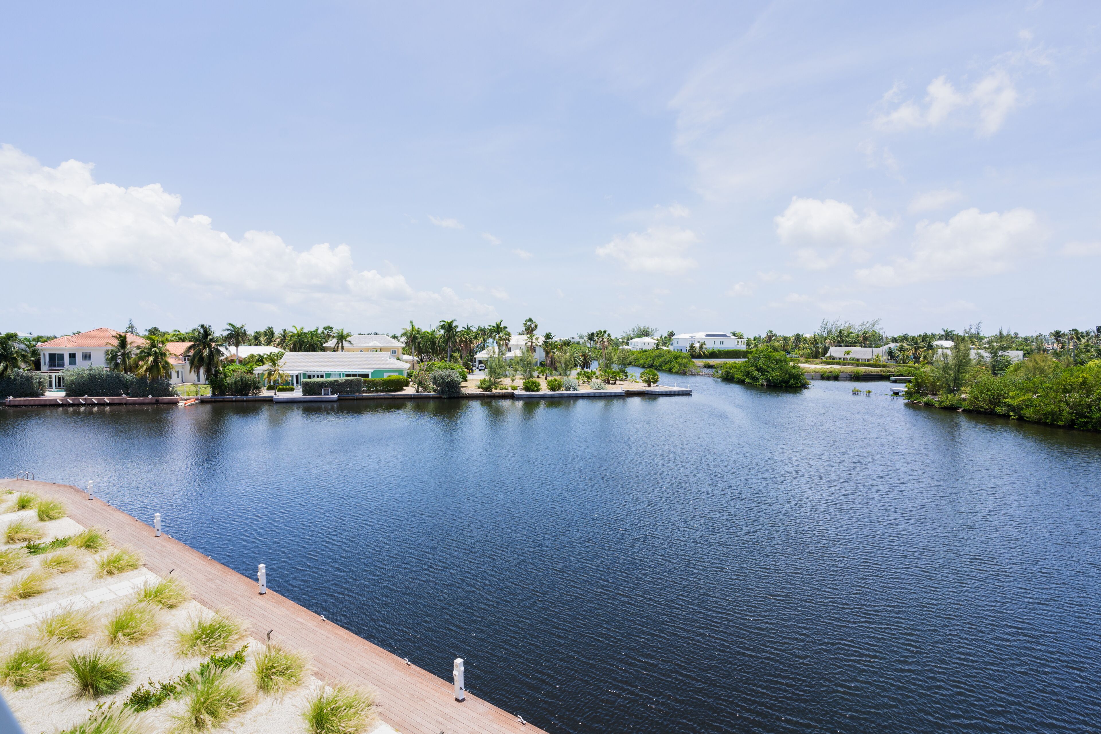 A waterfront property with a dock, water, and surrounding greenery.