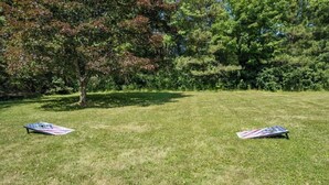 Eine begrünte Außenfläche mit zwei Frisbees im Stil der US-amerikanischen Flagge auf dem Boden.
