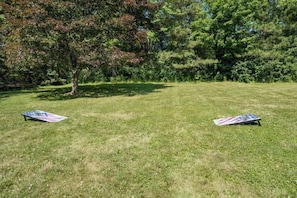 A grassy outdoor area with two American flag-themed frisbees on the ground.
