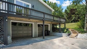 Ein zweistöckiges Haus mit überdachter Garage und einer Holzterrasse.