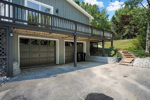 A two-story house with a covered garage and a wooden deck.