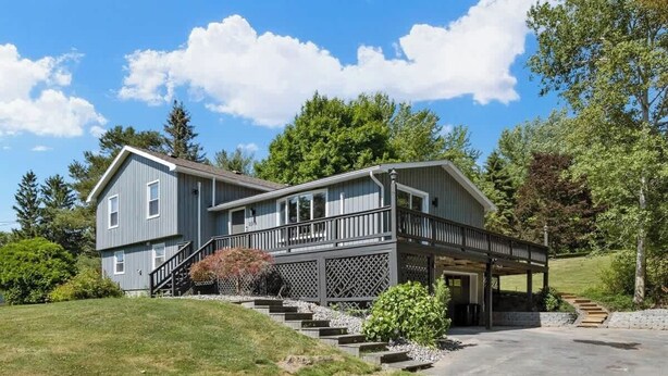 A two-story house with a covered porch and a staircase leading to the entrance. - Finger Lakes ~ Firepit, Spacious, Wine Country (Skaneateles)