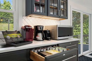 Una cocina moderna con cafetera, microondas y área de café.