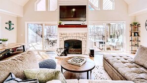 A spacious living room with a fireplace, large windows, and a cozy seating area. - Lakefront retreat for family, friends & fun! (Lake Norman of Catawba)
