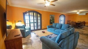 A living room with a blue sofa, a wooden coffee table, and a TV on a wooden stand.