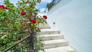 A staircase with a metal railing, surrounded by green foliage and red flowers. - Hidden Gem Apartment - Two Bedroom Apartment with Terrace and Sea View (Molunat)