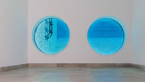 Two circular windows with blue-tinted glass, a plain white wall, and a tiled floor. - seafront brand new luxury villa swimming pool -ideal for families, free transfer (Μακρύ-Γιαλός)