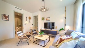 A modern living room with wicker furniture, a flat-screen TV, and a large window. - Villa QUARNARO with heated pool (Omišalj)