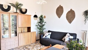 A modern living space with a wooden cabinet, a dark grey sofa, and a mosaic tile floor. - Charming Perledo Retreat with Lake View, Balcony & Parking (Perledo)
