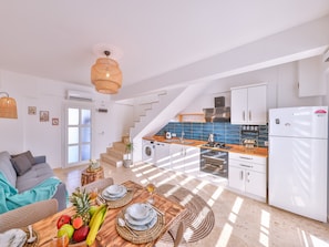A modern kitchen with white cabinets, a built-in oven, and a refrigerator. - Villa Ay (Kas)