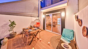 A cozy outdoor patio with a dining table, chairs, and a hanging chair. - Villa Ay (Kas)