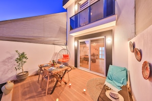 A cozy outdoor patio with a dining table, chairs, and a hanging chair. - Villa Ay (Kas)
