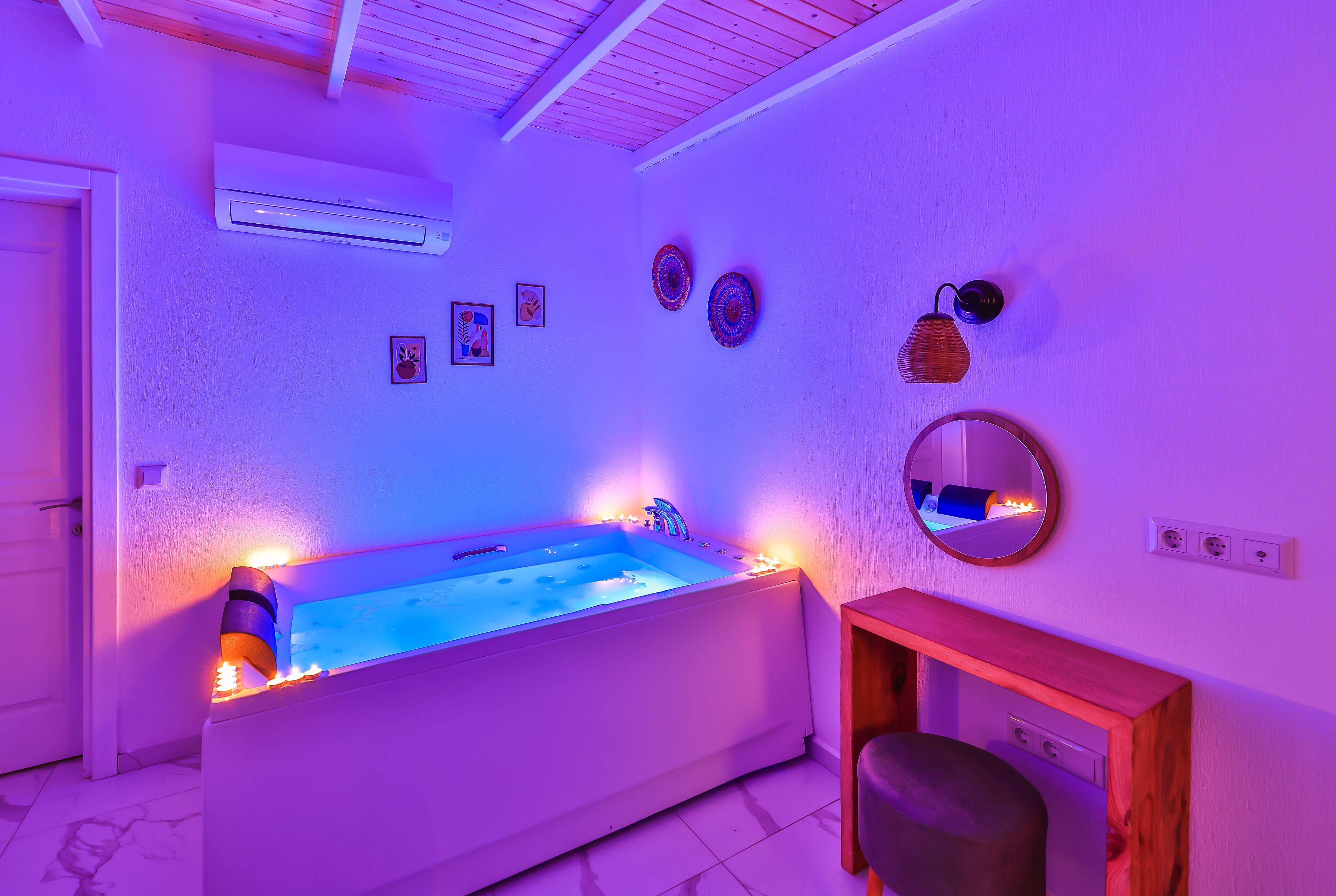 A modern bathroom with a freestanding bathtub, a wooden vanity, and decorative wall art.