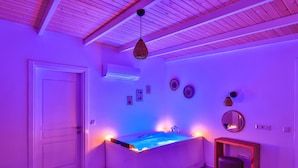 A room with a bed, a small table, a chair, and a wall-mounted mirror. - Villa Ay (Kas)