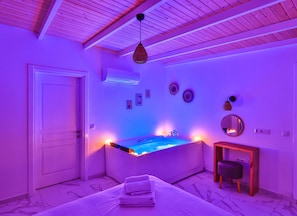 A room with a bed, a small table, a chair, and a wall-mounted mirror. - Villa Ay (Kas)