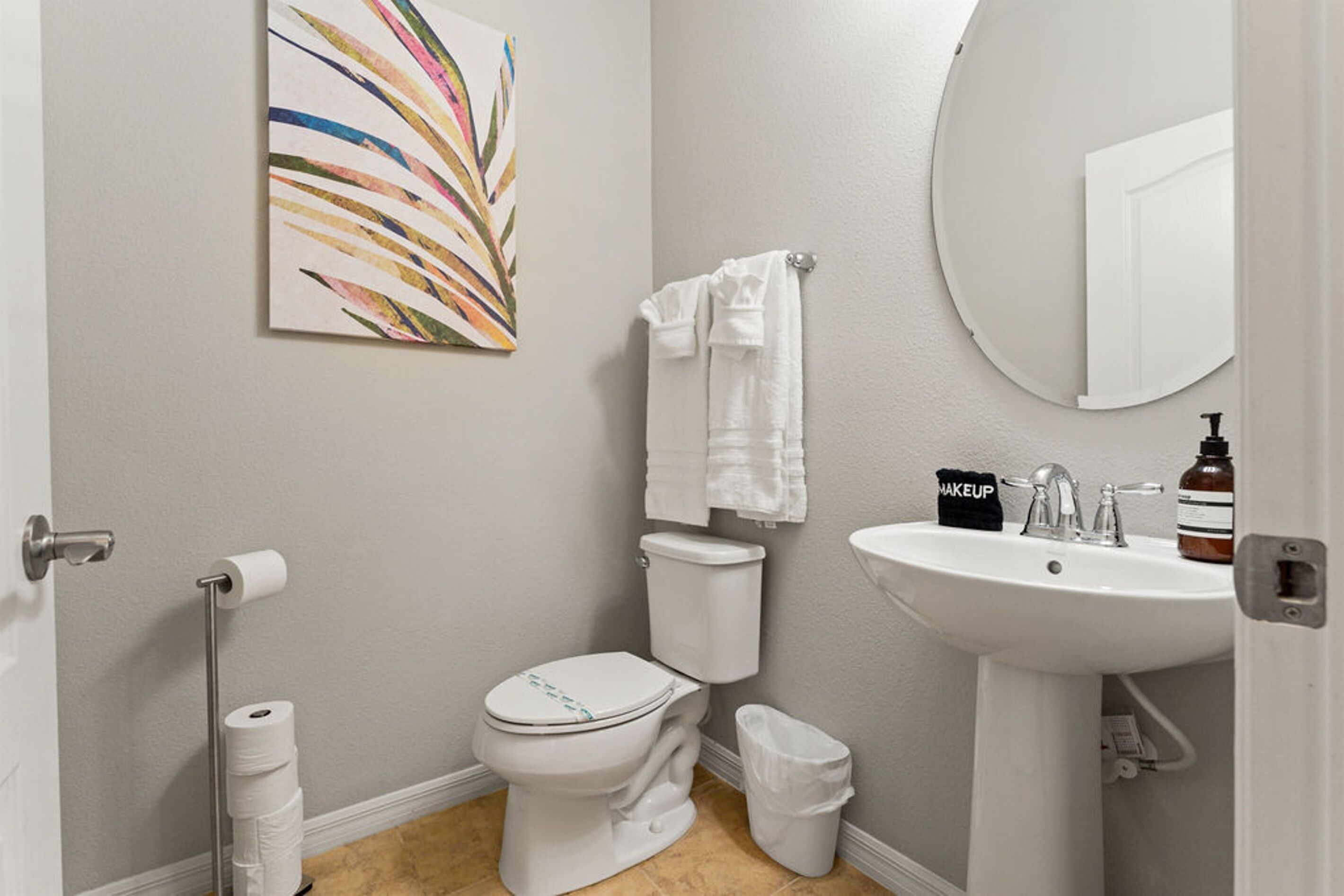 A bathroom with a toilet, sink, and a towel rack.