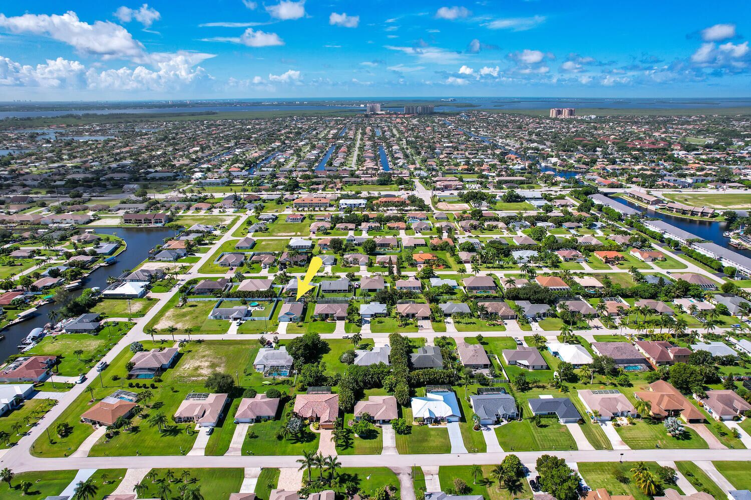 An aerial view of a residential area with houses, streets, and a river.