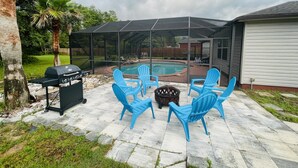 Un patio trasero con techo, piscina y mobiliario exterior.
