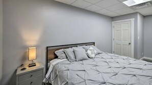 Ein Schlafzimmer mit Bett, Nachttisch und Beistelltisch.