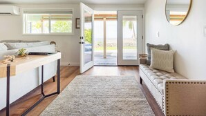 A modern living room with a sofa, a coffee table, and a large mirror. - Hale 'Io • Remodeled 2/2 Luxury • AC • Ocean View (Kailua-Kona)