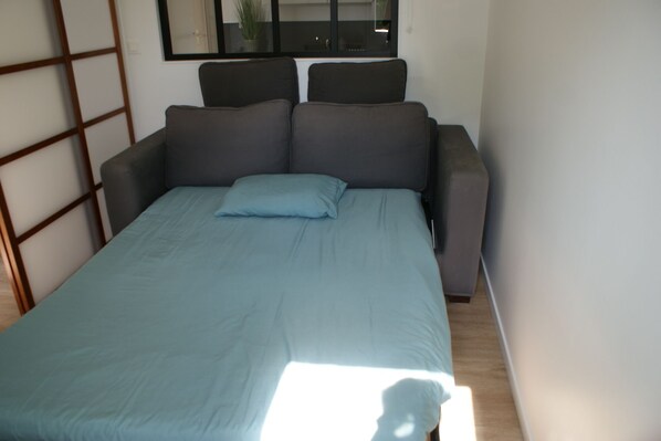 A room with a bed, a window, and a plant. - Port de Vannes T3 of 53m2, new apartment, 500m from the port, 2 bedrooms (Vannes)