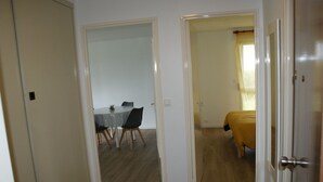 Een gang met een eetgedeelte en een slaapkamer.