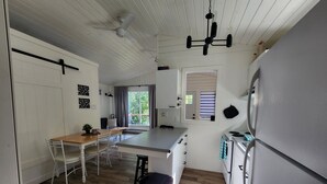 Una cocina moderna con armarios blancos, una mesa de comedor de madera y una isla grande.