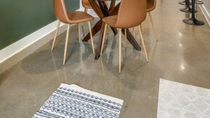 A dining area with a round table, four chairs, and a small potted plant.
