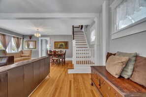 A spacious living area with a wooden staircase, a dining table, and a sofa. - 3 Bedroom Beach Retreat (Asbury Park)