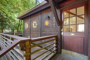 Stylish entrance with a wooden bench and decorative sun motifs above the door.
