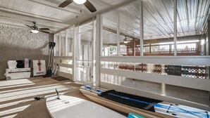 A spacious room with large windows, ceiling fans, and a view of the outdoors.