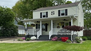 A two-story house with a porch, a mailbox, and a number "29" on the front door. - Cozy and completely updated The Farmhouse at Lanterman's Village (Youngstown)