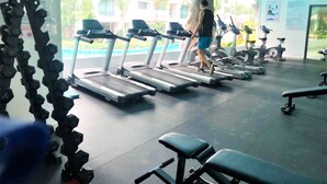 Ein Fitnessraum mit Laufbändern, Hanteln und Trainingsgeräten.