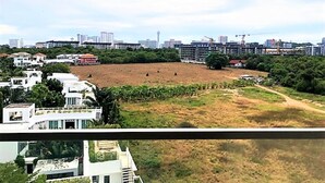 Ein Wohngebiet mit modernen Gebäuden, einer weiten offenen Fläche und einer entfernten Stadtlandschaft.