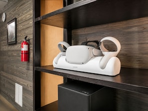 Una habitación moderna con una pared de madera, un extintor y un dispositivo electrónico blanco en una estantería.