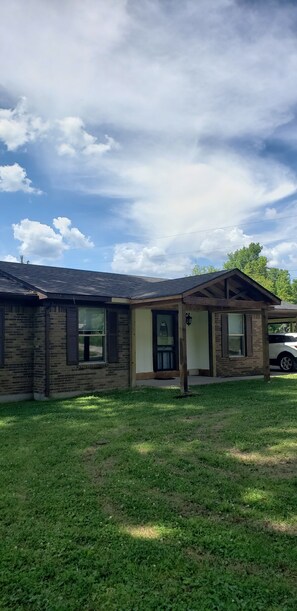 A single-story house with a brick exterior, a front porch, and a garage. - All Newly remodeled-- stylish luxury nestled in rural neighborhood - Forest View (Stanton)