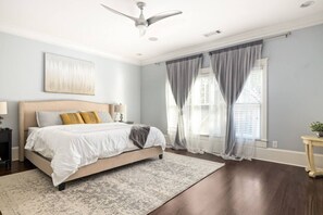 A bedroom with a large bed, a ceiling fan, and a window with curtains. - Luxury 6-Bedroom Home in Prime Decatur Neighborhood, Near DT ATL (Decatur)