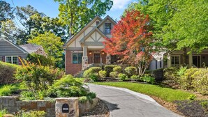 A residential driveway leading to a house with a stone mailbox, surrounded by well-maintained landscaping and trees. - Luxury 6-Bedroom Home in Prime Decatur Neighborhood, Near DT ATL (Decatur)