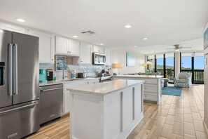 Una cocina moderna con armarios blancos, electrodomésticos de acero inoxidable y una isla grande.