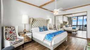 A spacious bedroom with a large bed, a nightstand, a chair, and a balcony view. - Sandpiper Condominiums 1206, Panoramic Gulf Views w/ direct access to Mustang Island/Port A beaches. (Port Aransas)