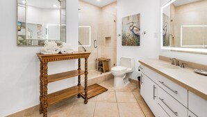 A modern bathroom with a vanity, a toilet, and a shower area. - Sandpiper Condominiums 1206, Panoramic Gulf Views w/ direct access to Mustang Island/Port A beaches. (Port Aransas)