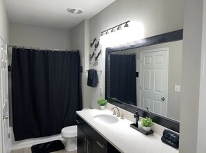 Combined shower/tub, hair dryer, towels, soap - Luxury Modern Condo by Lenox Mall (Atlanta)