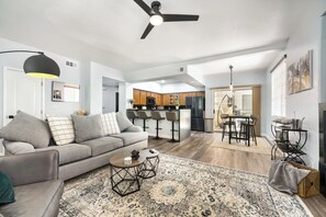 Un salon moderne avec un canapé, une table basse et un tapis à motifs.