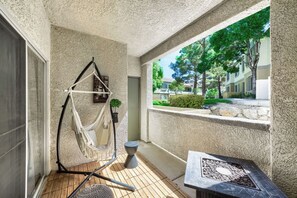 A balcony with a hammock, a small table, and a fire pit. - RARE GATED NEWLY REMODELED Summerlin Luxury 2 Bed / 2 Bath Condo (Las Vegas)