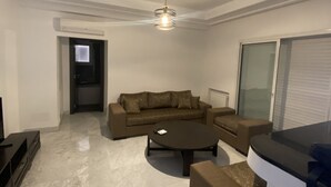 En moderne stue med en sofa, et sofabord og et TV-møbel.