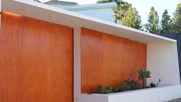 A modern building with a flat roof, white exterior walls, and a wooden panel accent.
