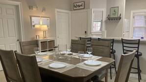 Comedor con una mesa rectangular dispuesta para seis personas, rodeada de sillas de madera.