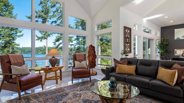 A spacious living room with large windows, a leather sofa, a glass coffee table, and a patterned rug. - New Listing! Amazing Lakefront 4 Bedroom 4 1/2 Bath,Sleeps 10, w/ Bonus room,Incredible Views,Dock (Florence)
