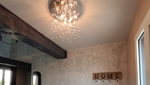 Eine moderne Küche mit Marmorarbeitsplatte, eingebautem Ofen und einer Chandelüster.